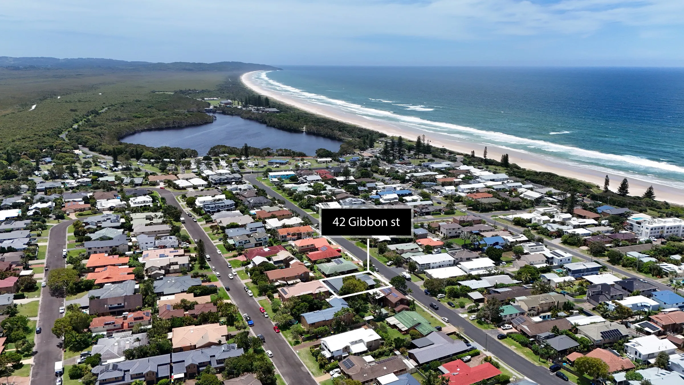 Drone view over a beachside town and lake toward the ocean, Northern Rivers, by Kris Cook