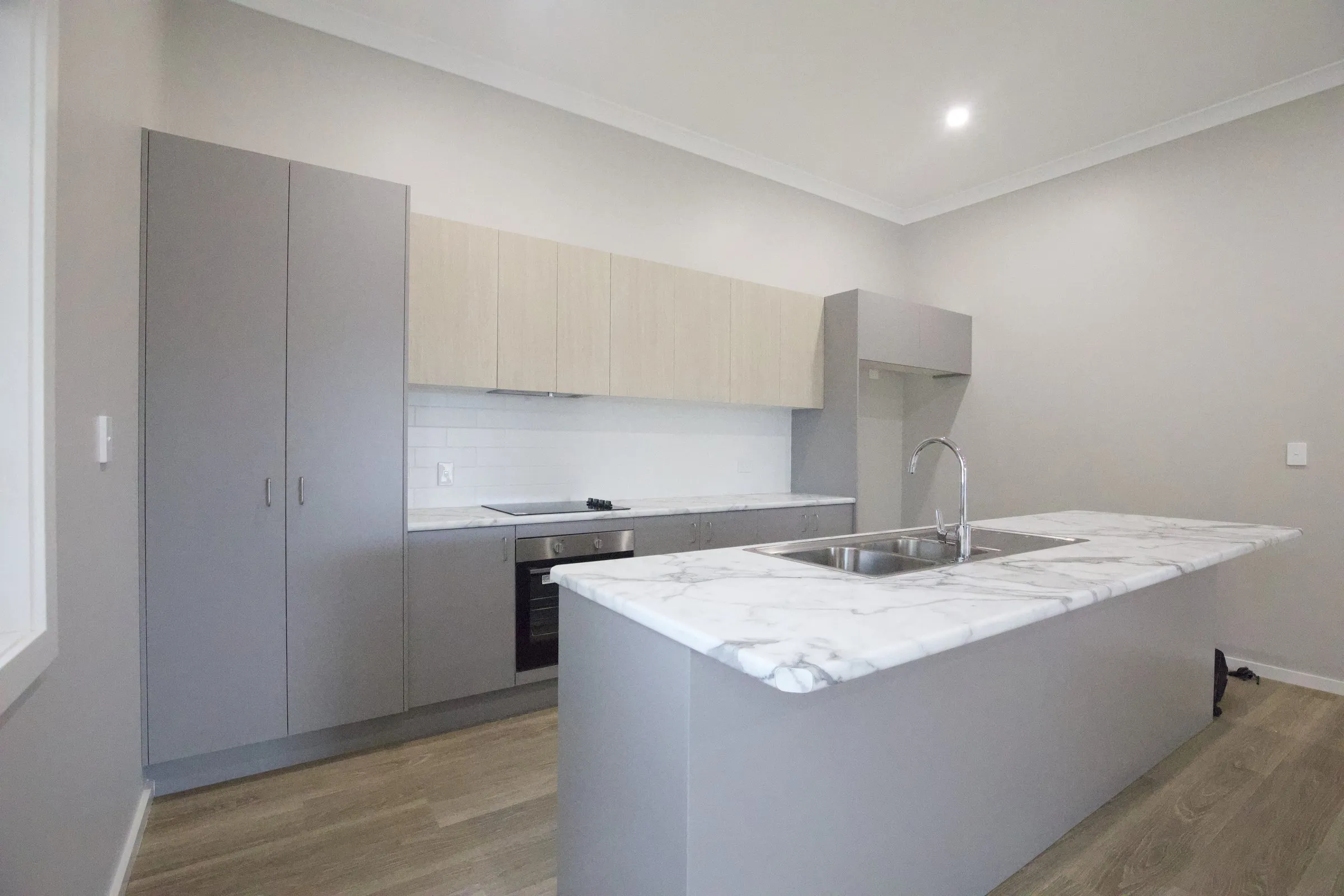 New kitchen with a stone island bench, real estate photography by Kris Cook